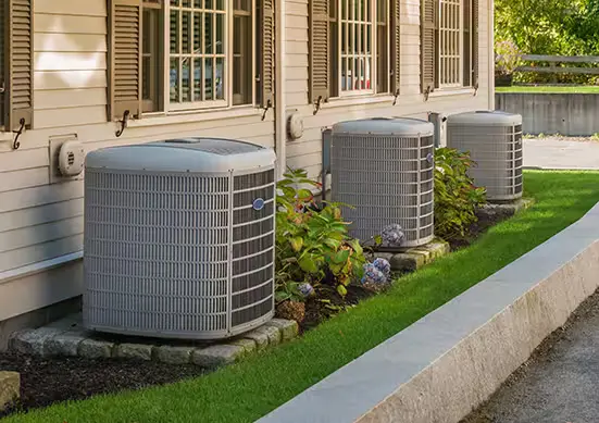 AC units lined up on the side of a house