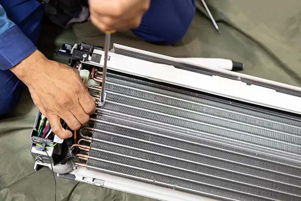 HVAC technician servicing evaporator coils