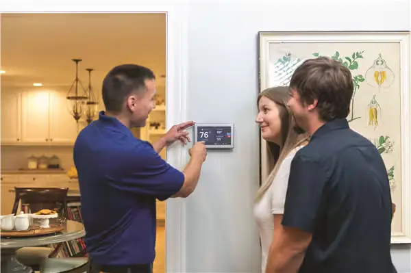 hvac repairman showcasing new thermostat