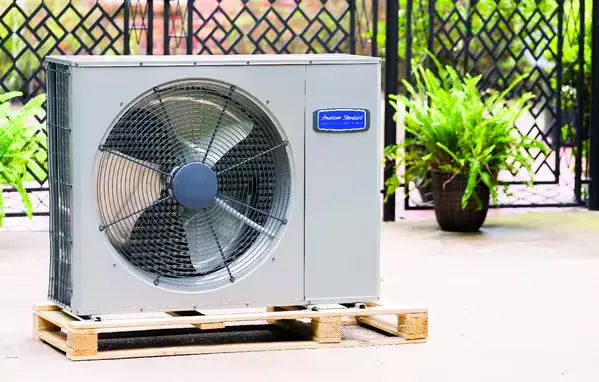 American Standard heat pump displayed outdoors on a wooden pallet